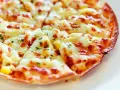 Pyszna pizza z tortilli, z ciągnącym się serem i ziołami, idealna na szybką przekąskę.