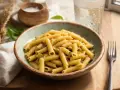 Penne z sosem pesto, idealne na szybki obiad. Dowiedz się, ile gotować makaron, by był al dente.