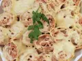 Zapiekana tortilla z szynką i ciągnącym się serem, udekorowana gałązką natki pietruszki. Pyszne danie gotowe do podania.