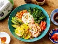 Kolorowy bowl z ryżem, łososiem, awokado, jajkiem sadzonym, jarmużem i kimchi. Pyszny bowl z lososiem na zdrowy obiad.