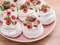 Mini bezy Pavlova z malinami i czekoladą, udekorowane listkami mięty. Idealne na deser.