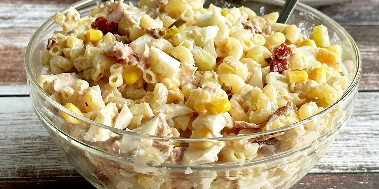 Pyszna sałatka z tuńczykiem i makaronem, jajkiem i kukurydzą w szklanej misce. Idealna na szybki lunch.