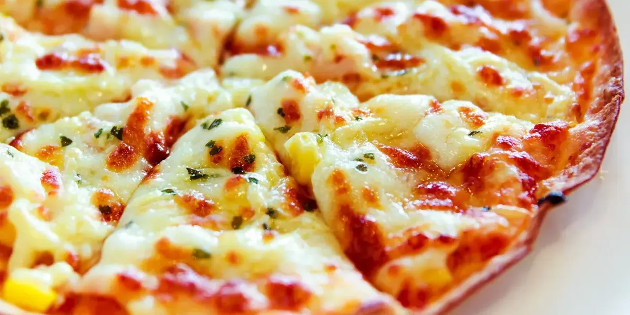 Pyszna pizza z tortilli, z ciągnącym się serem i ziołami, idealna na szybką przekąskę.