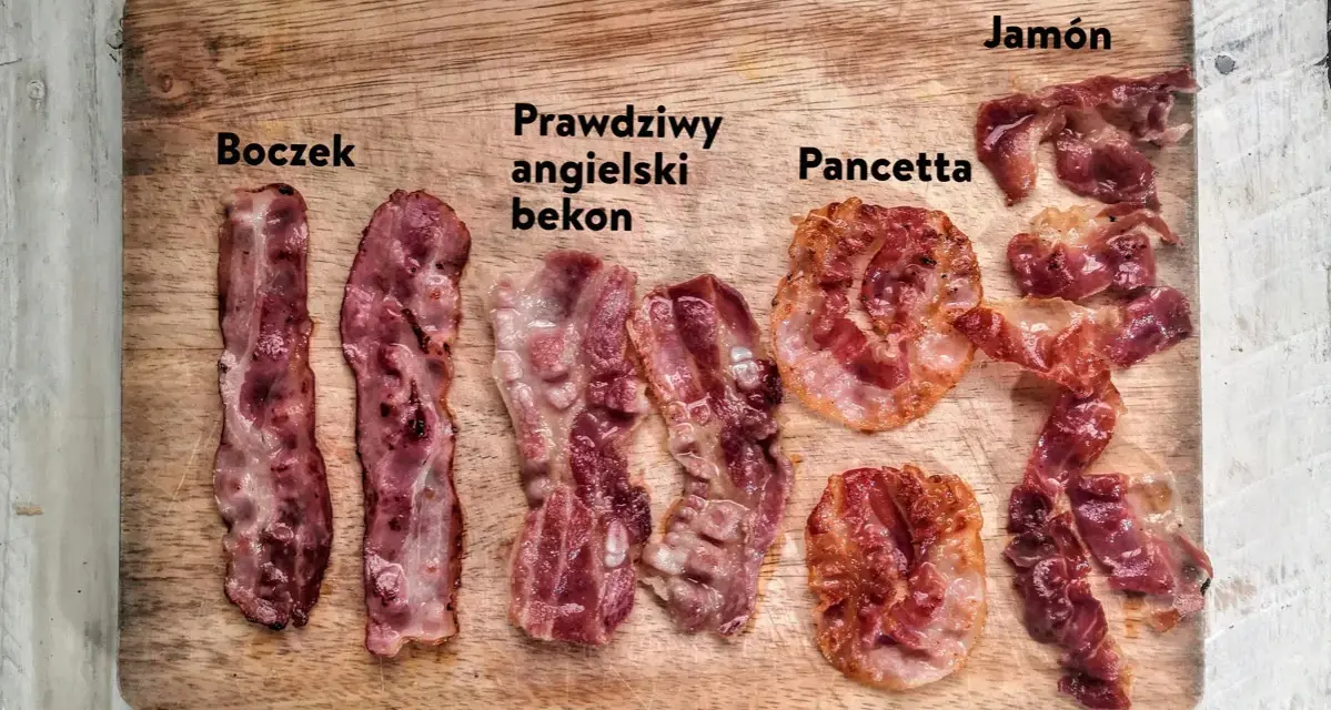 Boczek, prawdziwy angielski bekon, pancetta i jamón ułożone na desce. Różne rodzaje wędlin, każdy z nich ma swój unikalny wygląd.