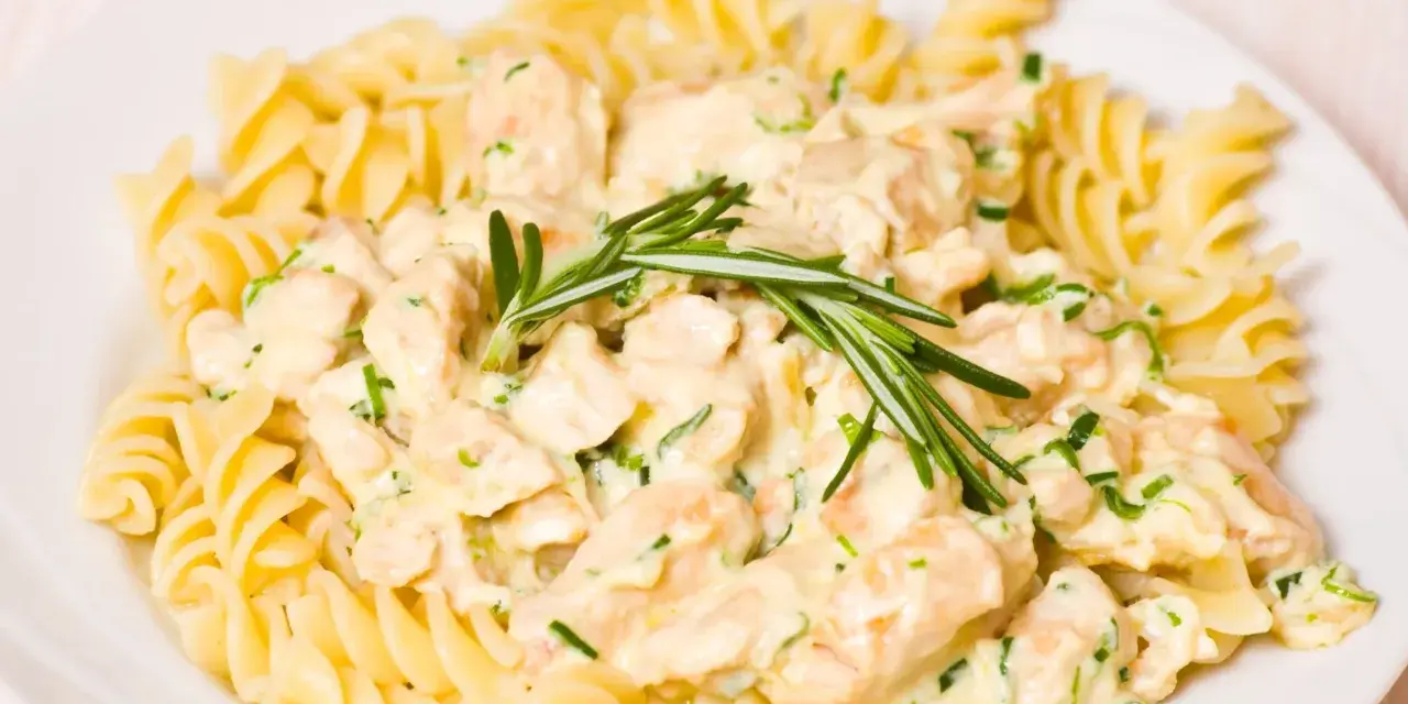Makaron fusilli z kurczakiem w kremowym sosie, ozdobiony rozmarynem.
