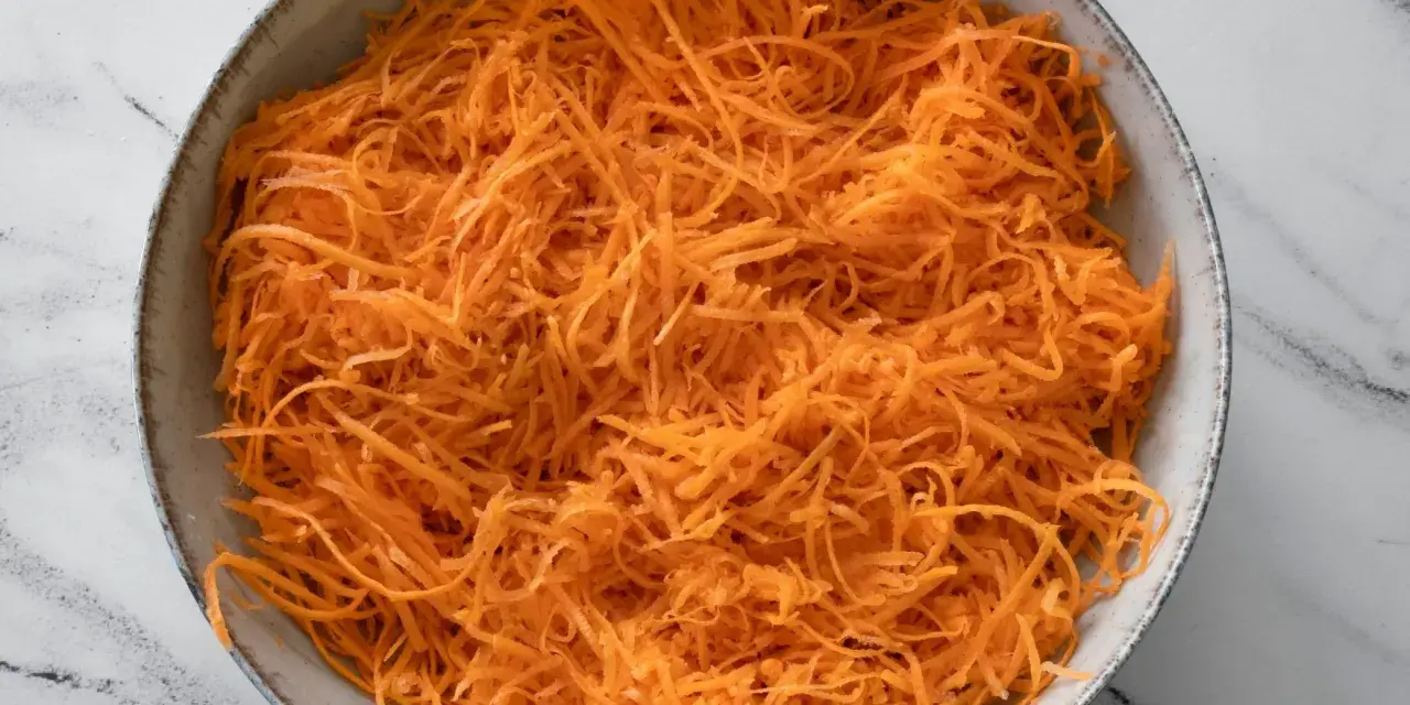 Miska tartej marchewki, idealnej jako dodatek do obiadu.