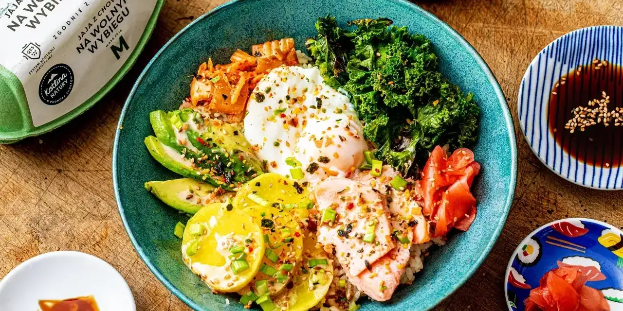 Kolorowy bowl z ryżem, łososiem, awokado, jajkiem sadzonym, jarmużem i kimchi. Pyszny bowl z lososiem na zdrowy obiad.