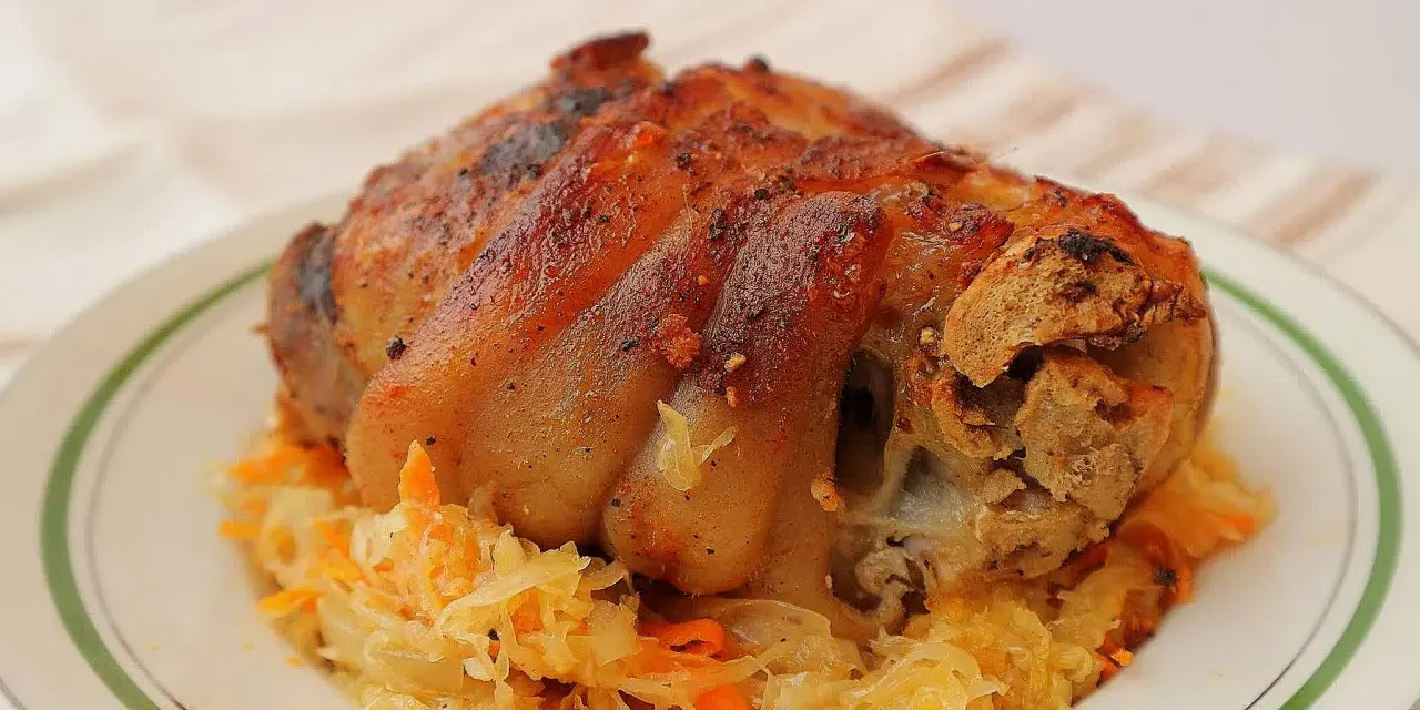 Soczysta golonka w kapuście kiszonej, pieczona do perfekcji, z chrupiącą skórką. Idealny polski obiad.