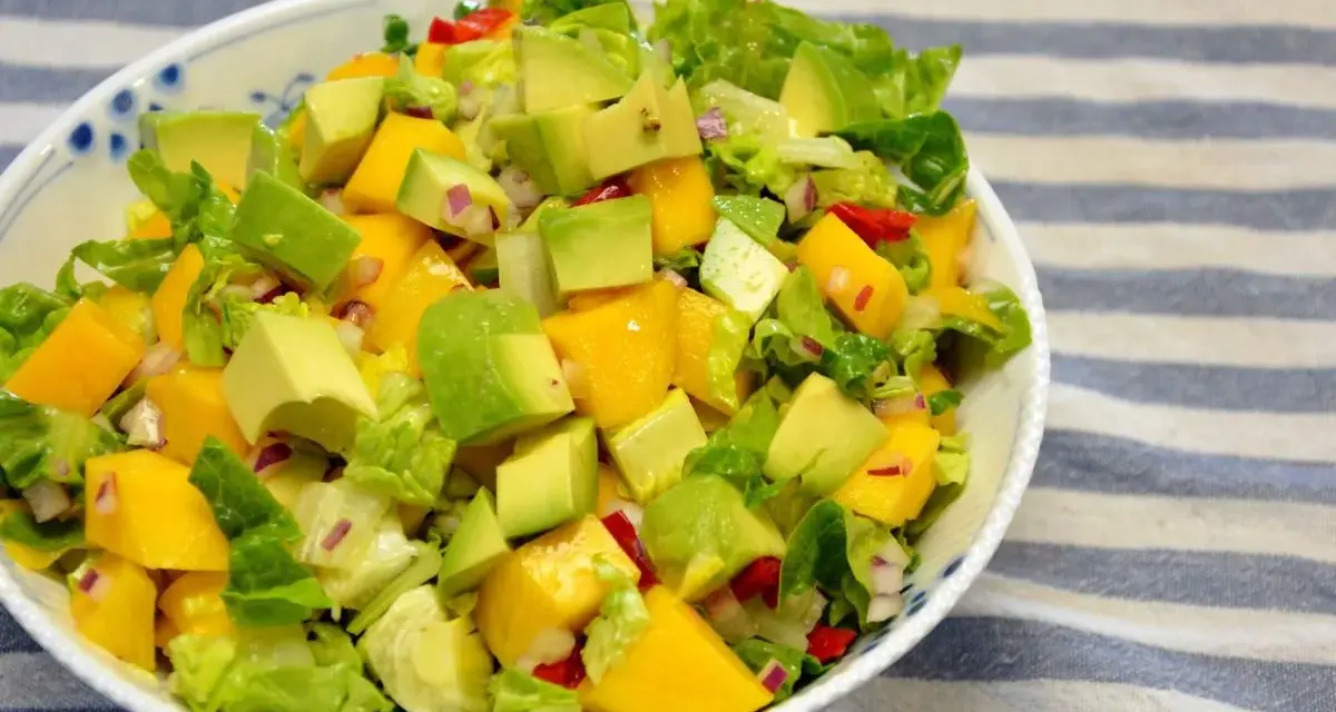 Kolorowa sałatka z mango, awokado, sałatą i czerwoną cebulą, pełna świeżości i smaku.