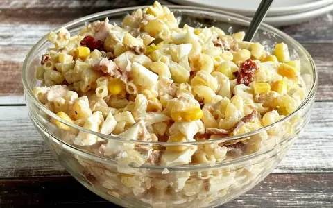 Pyszna sałatka z tuńczykiem i makaronem, jajkiem i kukurydzą w szklanej misce. Idealna na szybki lunch.