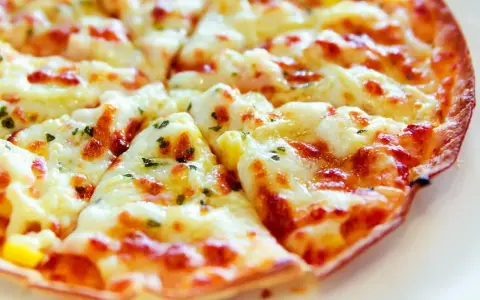 Pyszna pizza z tortilli, z ciągnącym się serem i ziołami, idealna na szybką przekąskę.
