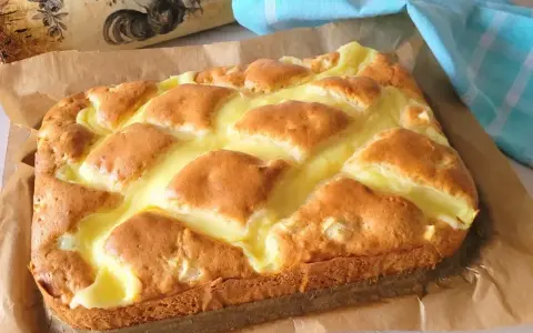 Puszyste ciasto z budyniem, z rumianymi kawałkami ciasta zatopionymi w kremowym budyniu. Idealne na deser.