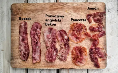 Boczek, prawdziwy angielski bekon, pancetta i jamón ułożone na desce. Różne rodzaje wędlin, każdy z nich ma swój unikalny wygląd.