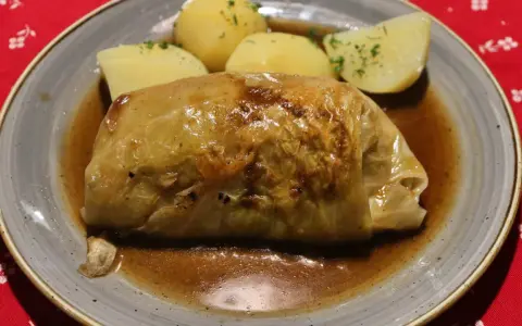 Pyszne gołąbki z kaszą gryczaną w sosie, podane z ziemniakami.