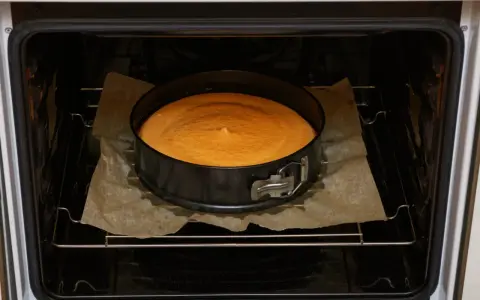 Sernik w tortownicy piecze się w piekarniku. Idealna temperatura to 170-180°C.