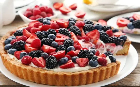Pyszna tarta z mascarpone, obficie udekorowana świeżymi malinami, jeżynami, borówkami i truskawkami. Idealna na letnie popołudnie.
