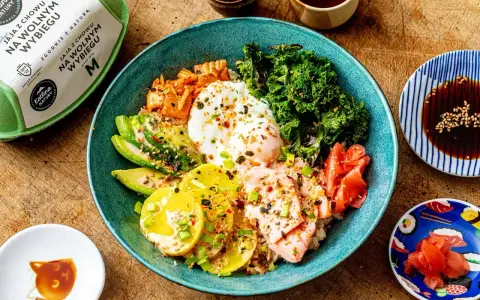 Kolorowy bowl z ryżem, łososiem, awokado, jajkiem sadzonym, jarmużem i kimchi. Pyszny bowl z lososiem na zdrowy obiad.