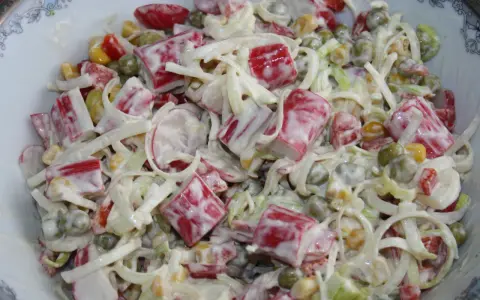 Pyszna sałatka z surimi, groszkiem, kukurydzą i porem, polana kremowym sosem.