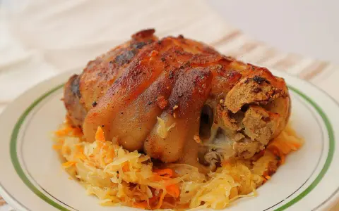 Soczysta golonka w kapuście kiszonej, pieczona do perfekcji, z chrupiącą skórką. Idealny polski obiad.