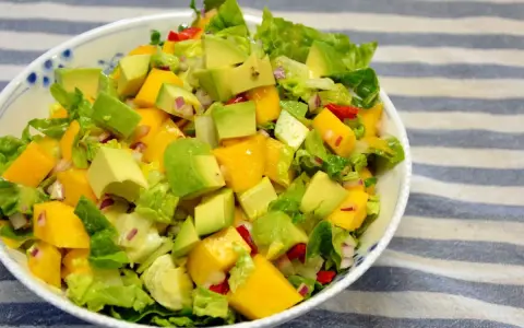 Kolorowa sałatka z mango, awokado, sałatą i czerwoną cebulą, pełna świeżości i smaku.