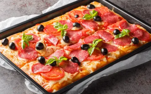 Chrupiąca pizza z ciasta francuskiego z salami, pomidorami, oliwkami i bazylią, prosto z blachy.