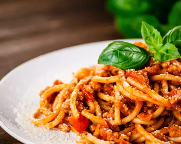 Pyszne spaghetti bolognese z mielonym mięsem, pomidorami i bazylią. Idealne pytanie: jakie mięso do spaghetti?
