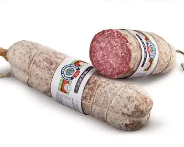 Dwie podłużne kiełbasy, jedna przekrojona, ukazująca różowe mięso i tłuszcz. Z czego jest salami? Z wieprzowiny i wołowiny, przyprawione.
