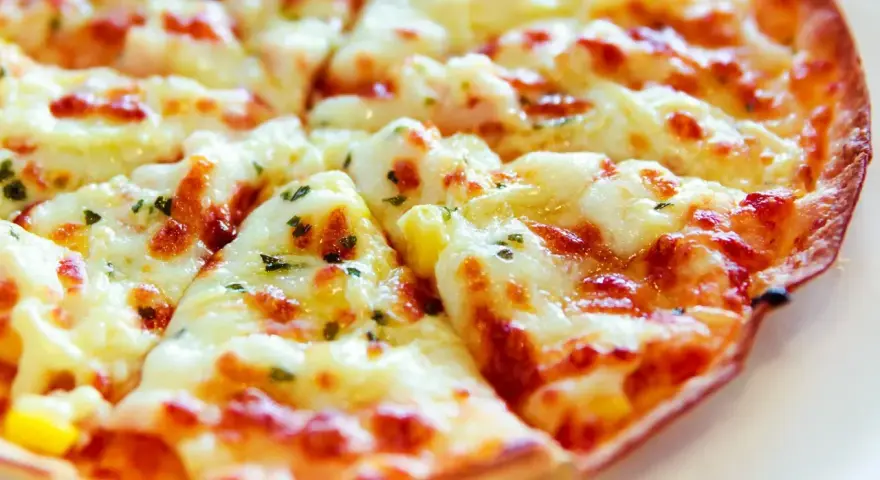 Pyszna pizza z tortilli, z ciągnącym się serem i ziołami, idealna na szybką przekąskę.