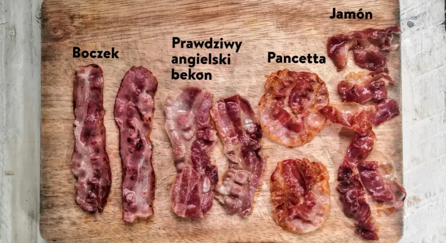 Boczek, prawdziwy angielski bekon, pancetta i jamón ułożone na desce. Różne rodzaje wędlin, każdy z nich ma swój unikalny wygląd.