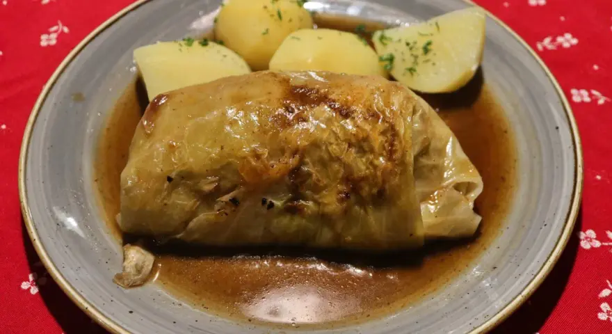 Pyszne gołąbki z kaszą gryczaną w sosie, podane z ziemniakami.