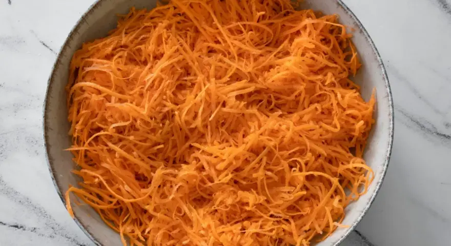 Miska tartej marchewki, idealnej jako dodatek do obiadu.