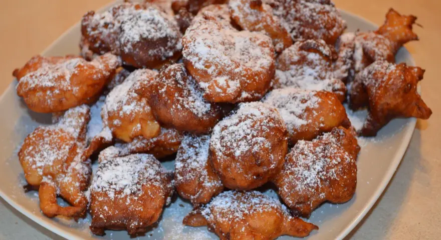 Puszyste paczki z serka homo, posypane cukrem pudrem, kuszą swoim złotym kolorem i apetycznym wyglądem.