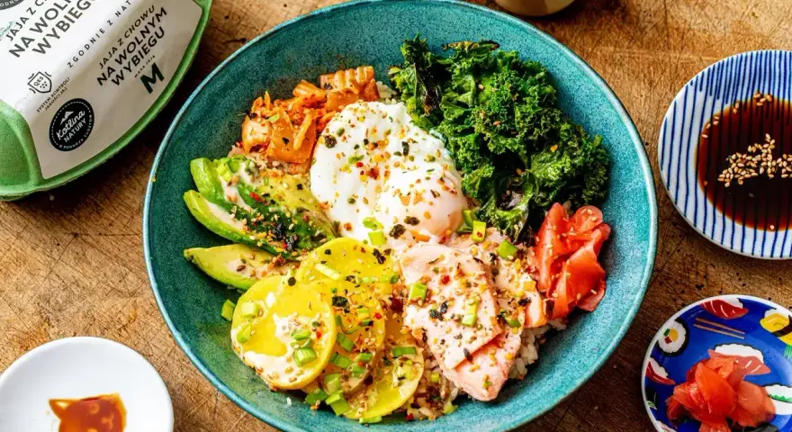 Kolorowy bowl z ryżem, łososiem, awokado, jajkiem sadzonym, jarmużem i kimchi. Pyszny bowl z lososiem na zdrowy obiad.