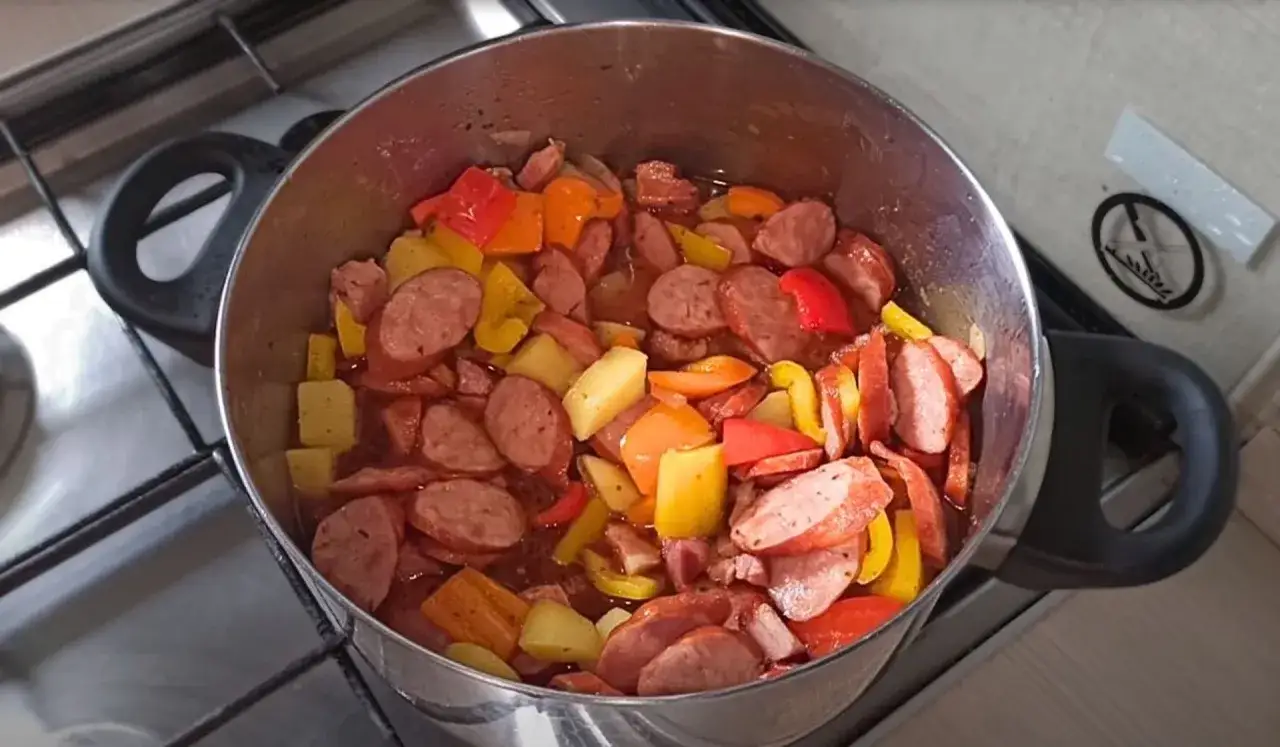 Szybkie dania jednogarnkowe: kiełbasa, ziemniaki i kolorowa papryka gotujące się w garnku.