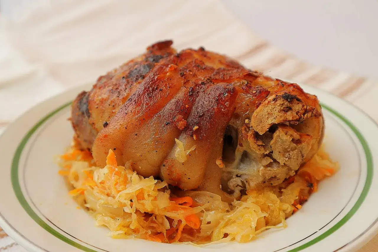 Apetyczna golonka w kapuście kiszonej, pieczona do perfekcji, z chrupiącą skórką. Idealny polski obiad.