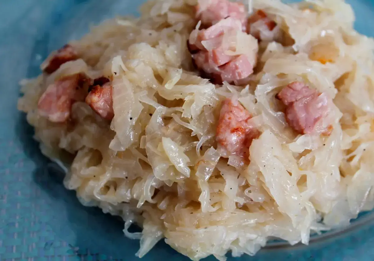 Pyszna kapusta zasmażana z boczkiem, podana na talerzu. Aromatyczne danie, które zachwyca smakiem.