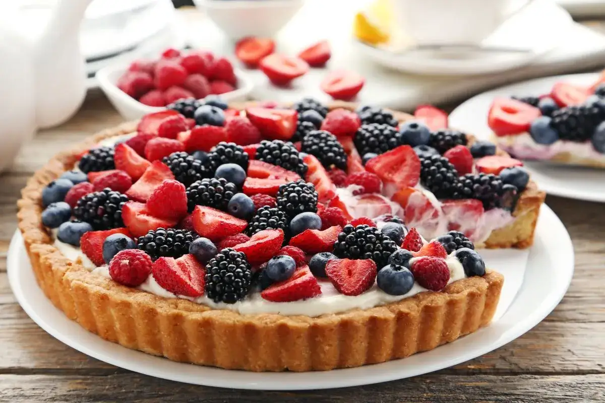 Pyszna tarta z mascarpone, udekorowana malinami, jeżynami i bor&oacute;wkami. Idealna na letnie popołudnie.