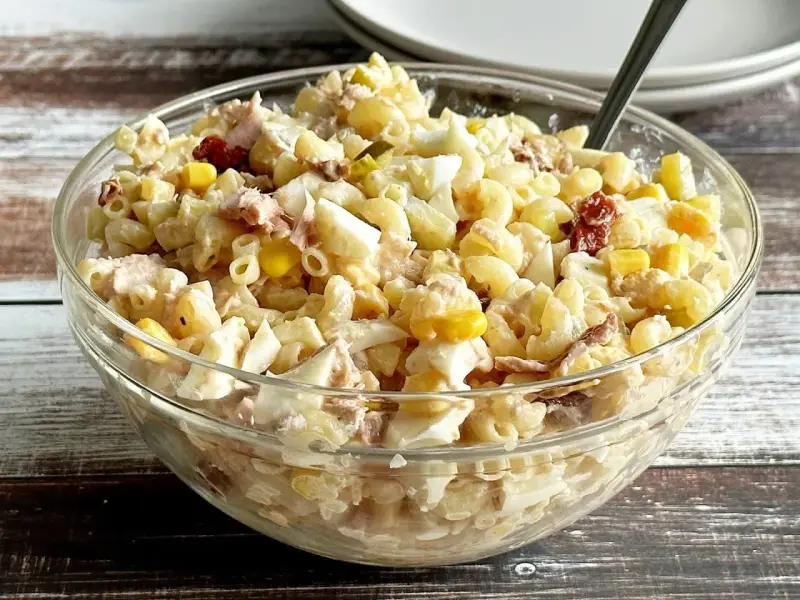 Pyszna sałatka z tuńczykiem i makaronem, jajkiem i kukurydzą w szklanej misce. Idealna na szybki lunch.