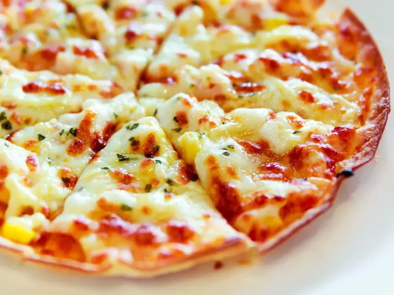 Pyszna pizza z tortilli, z ciągnącym się serem i ziołami, idealna na szybką przekąskę.